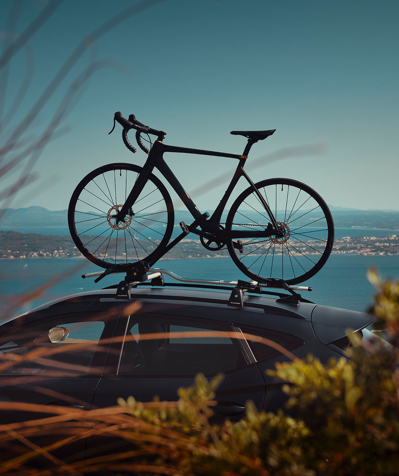 bike attached to the cupra formentors roof rack with blue sky backdrop.