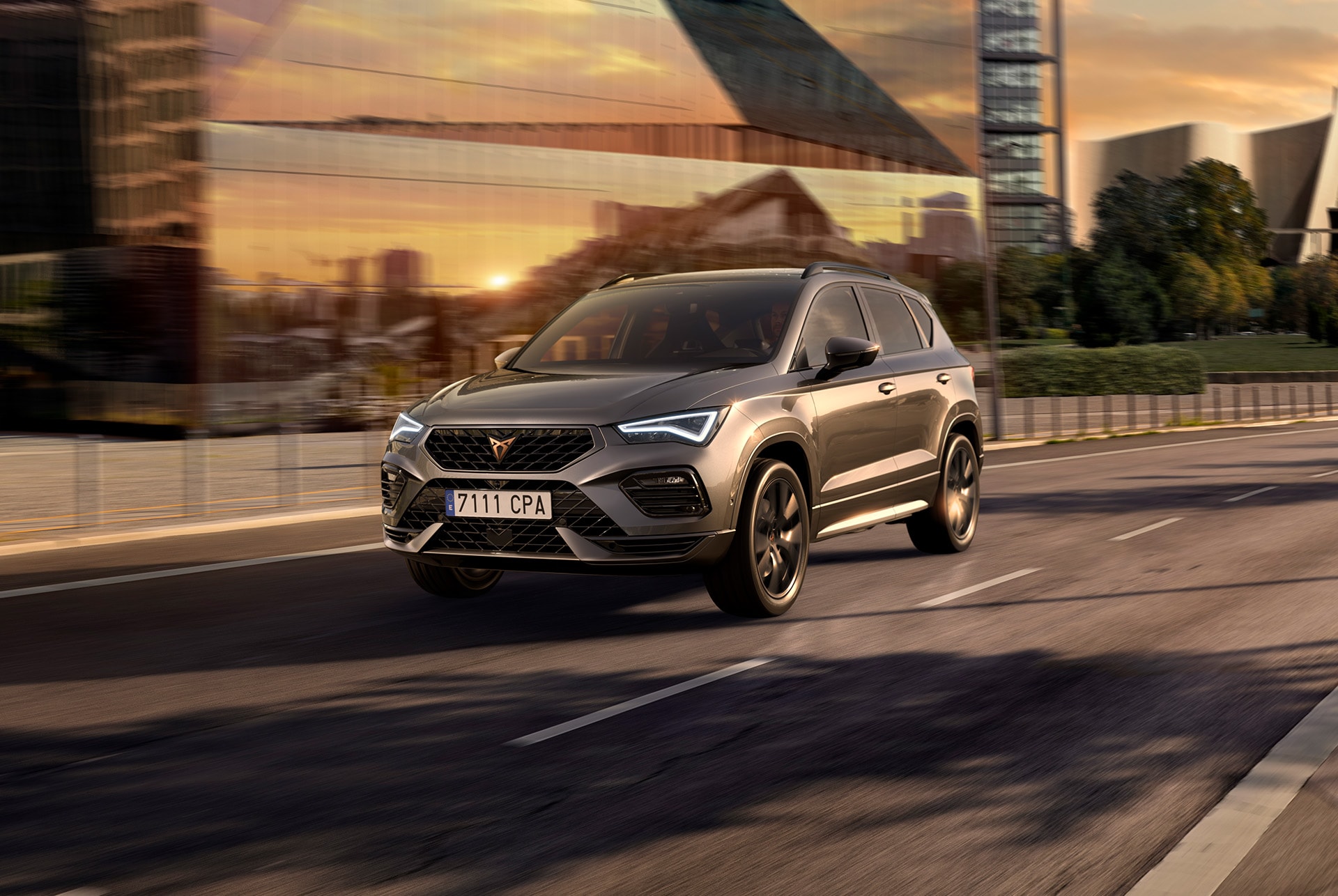 A grey cupra ateca suv displayed against a white background. The car features a bold front grille, led headlights and black matt alloy wheels, highlighting its sporty car design.
