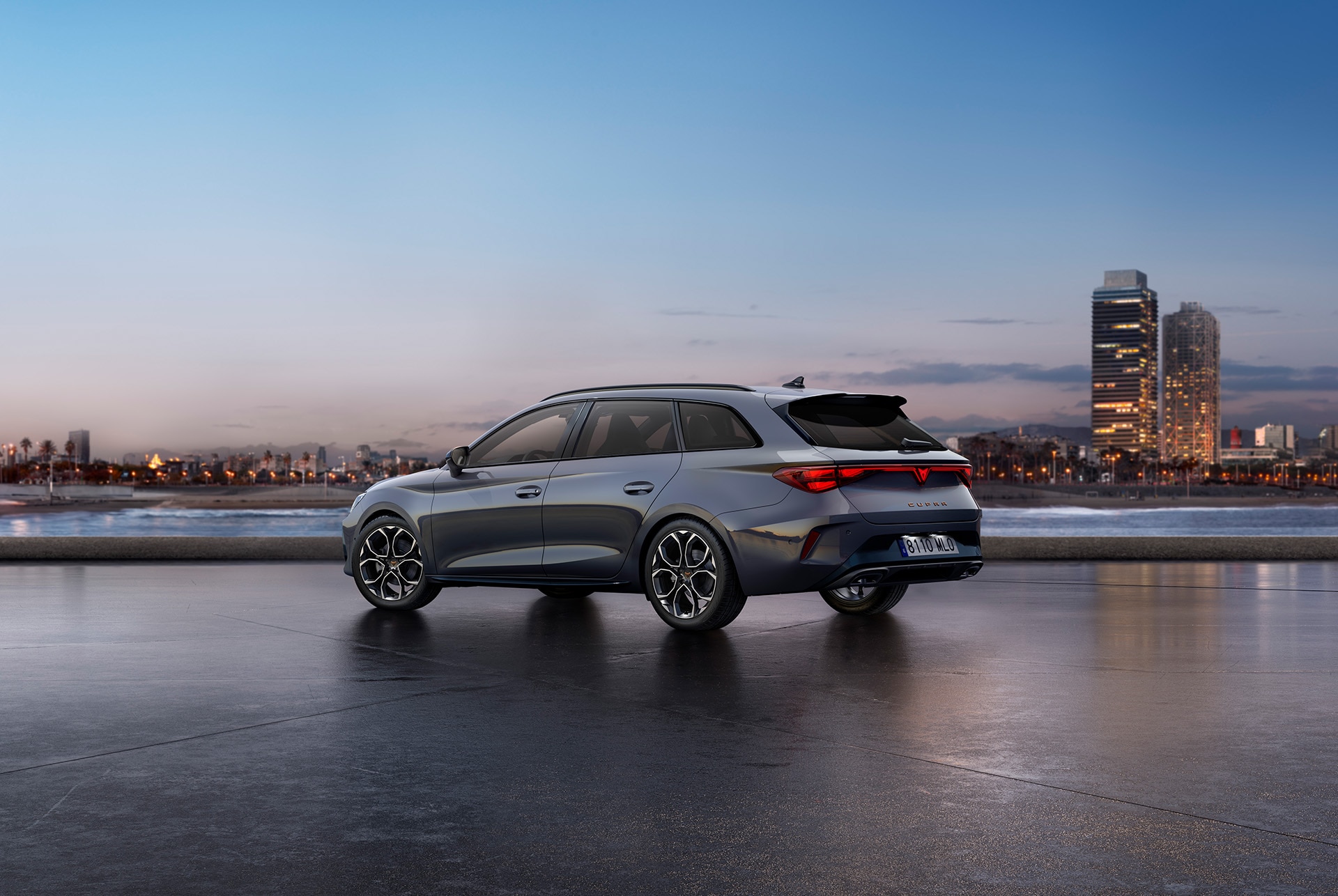 rear view shot of the new cupra leon sportstourer in grey parked in a diaphanous, outdoors setting at sunset, with the city in the background.