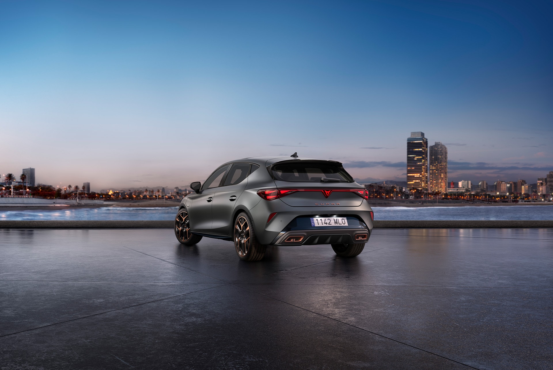 rear view shot of the new cupra leon 2025 in grey parked in a diaphanous, urban setting at sunset.