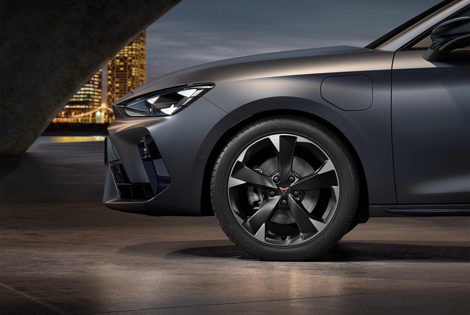 front side view of left machined silver garbi alloy wheel for the new Cupra Leon 2025, tyres, signature headlights and matt grey car body.