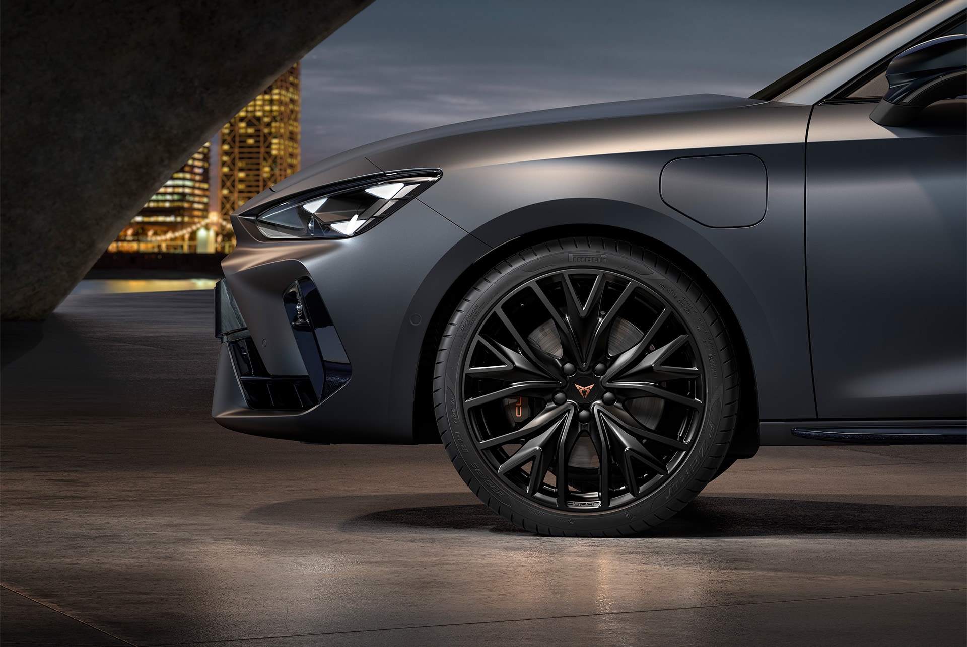 front side view of left alloy wheel in sport matt black for the new Cupra Leon 2025, tyres, signature headlights and matt grey body.