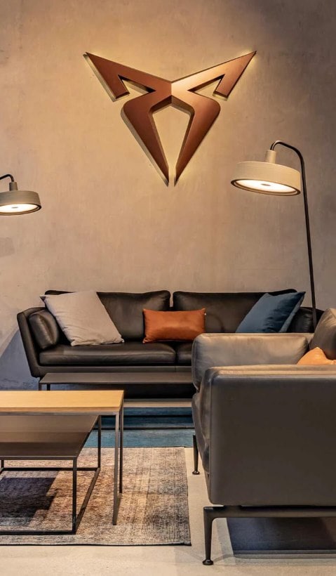 Interior view of a modern CUPRA City Garage, a sophisticated lounge area and contemporary interior design.