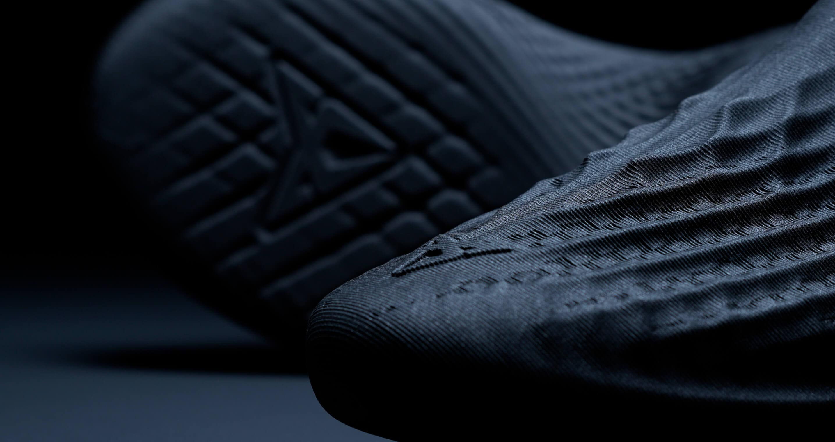 A close-up shot of a textured fabric with a prominent geometric emblem.