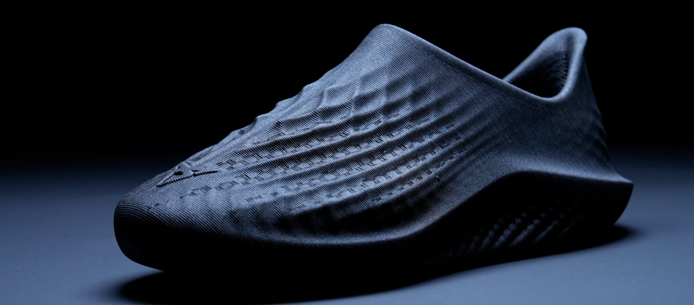 A close-up shot of a dark, textured shoe with a focus on the texture and form. A close-up shot of a dark, textured shoe with a focus on the texture and form.