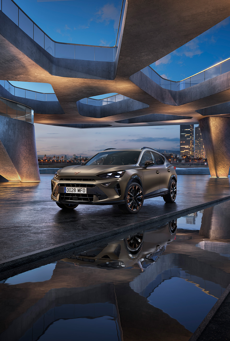 The 2024 Century bronze matte CUPRA Formentor parked on a reflective waterfront promenade. The sporty and aerodynamic new vehicle is positioned centre frame. The setting features futuristic architecture and Barcelona’s glowing city skyline at dusk.