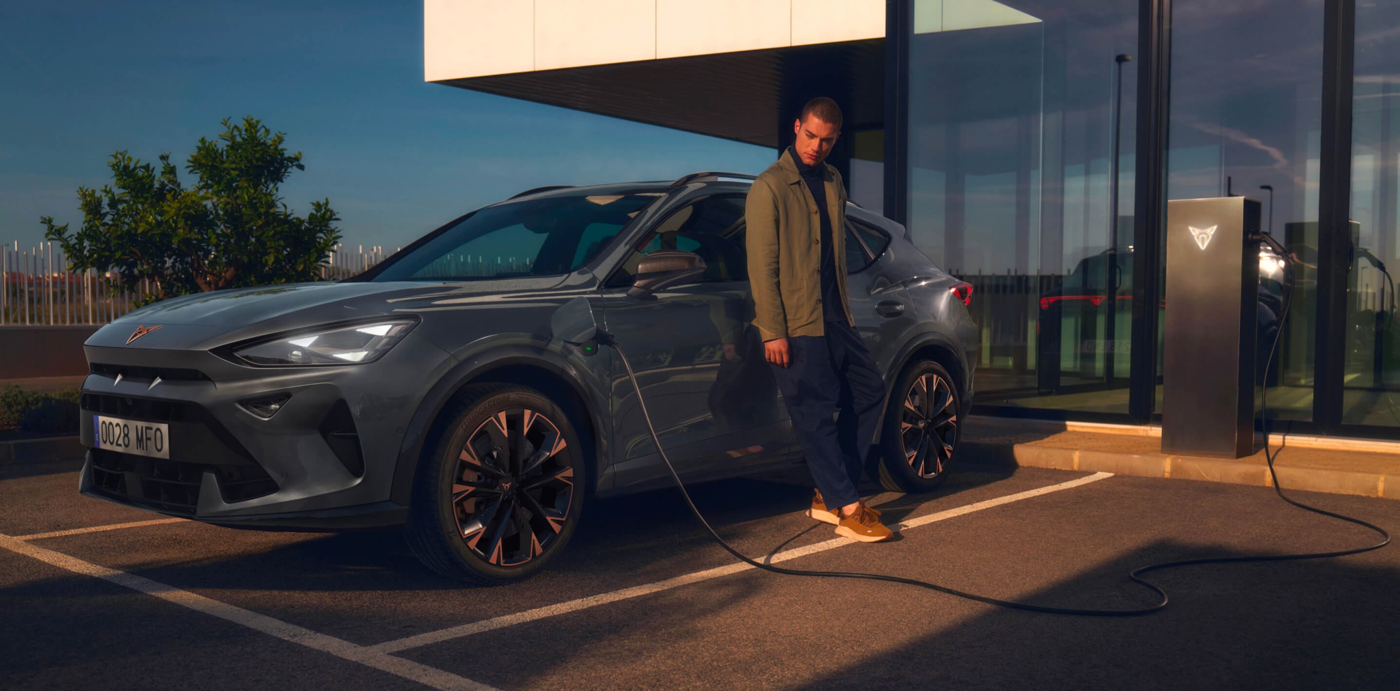 magnetic tech grey cupra formentor charging with man outside waiting