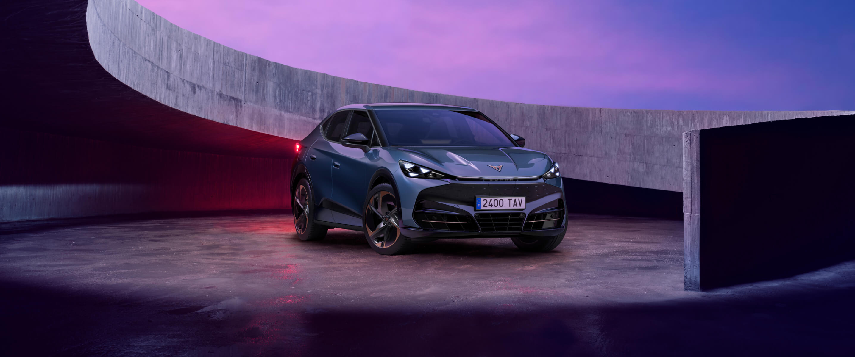 Cost of running an electric car vs petrol in the UK — CUPRA Tavascan VZ in Tavascan Blue, 3/4 front view in a futuristic urban setting.