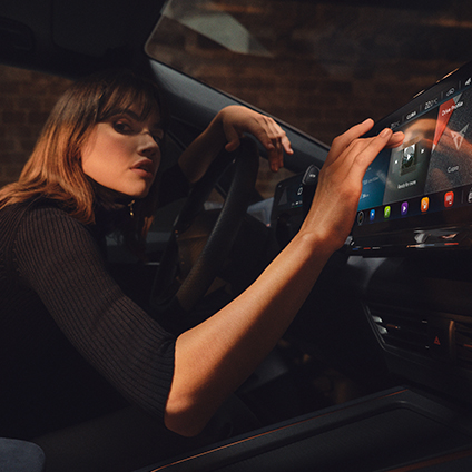 woman using cupra connect on the infotainment system inside the cupra born car