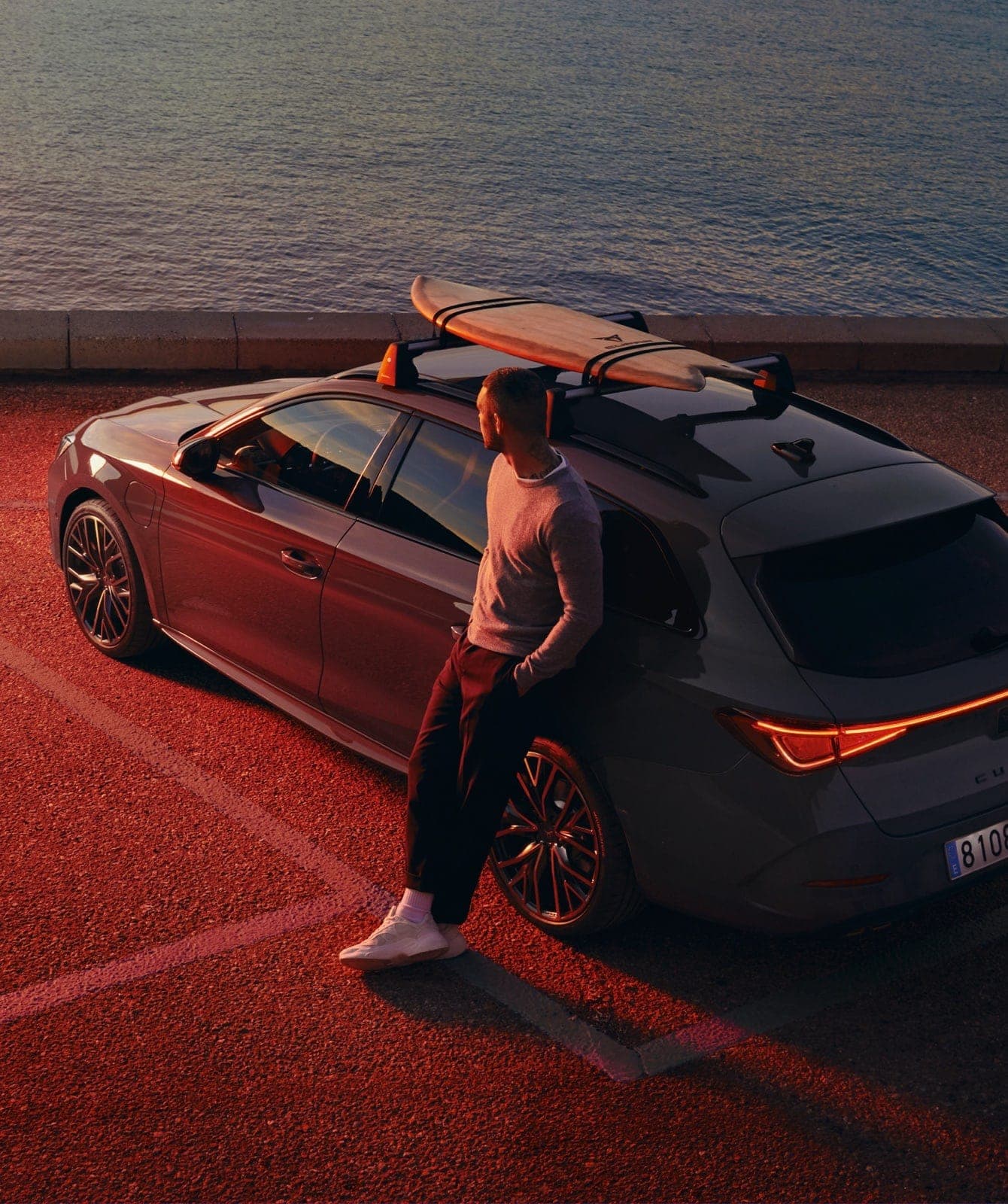 man-with-cupra-leon-in-front-sea-with-surf-rack