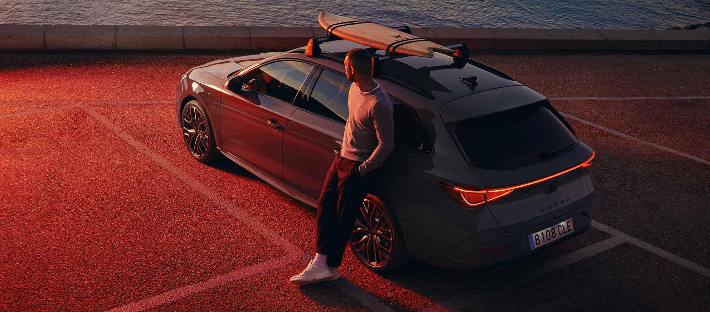 man-with-cupra-leon-in-front-sea-with-surf-rack