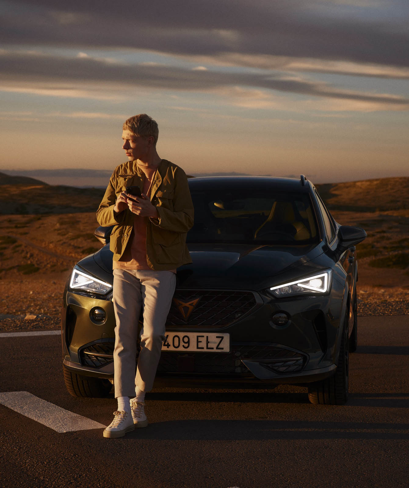 man-with-phone-in-front-of-cupra-leon